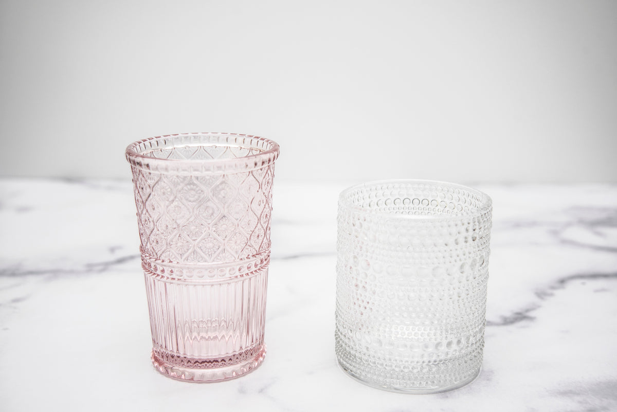 Hobnail and etched glasses in clear or pink glass accent the table
