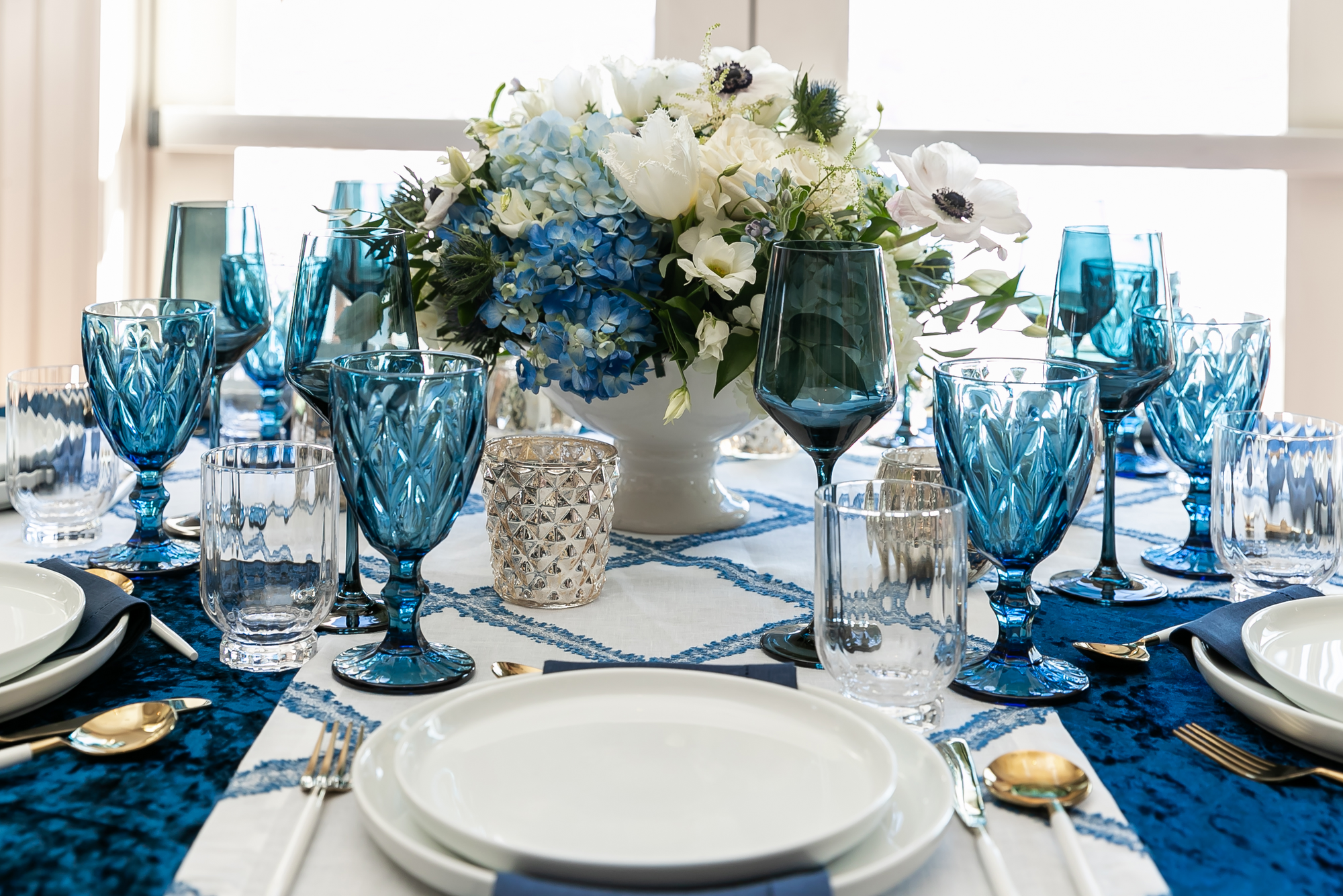 Blue wine glasses and blue goblets set on a wedding table